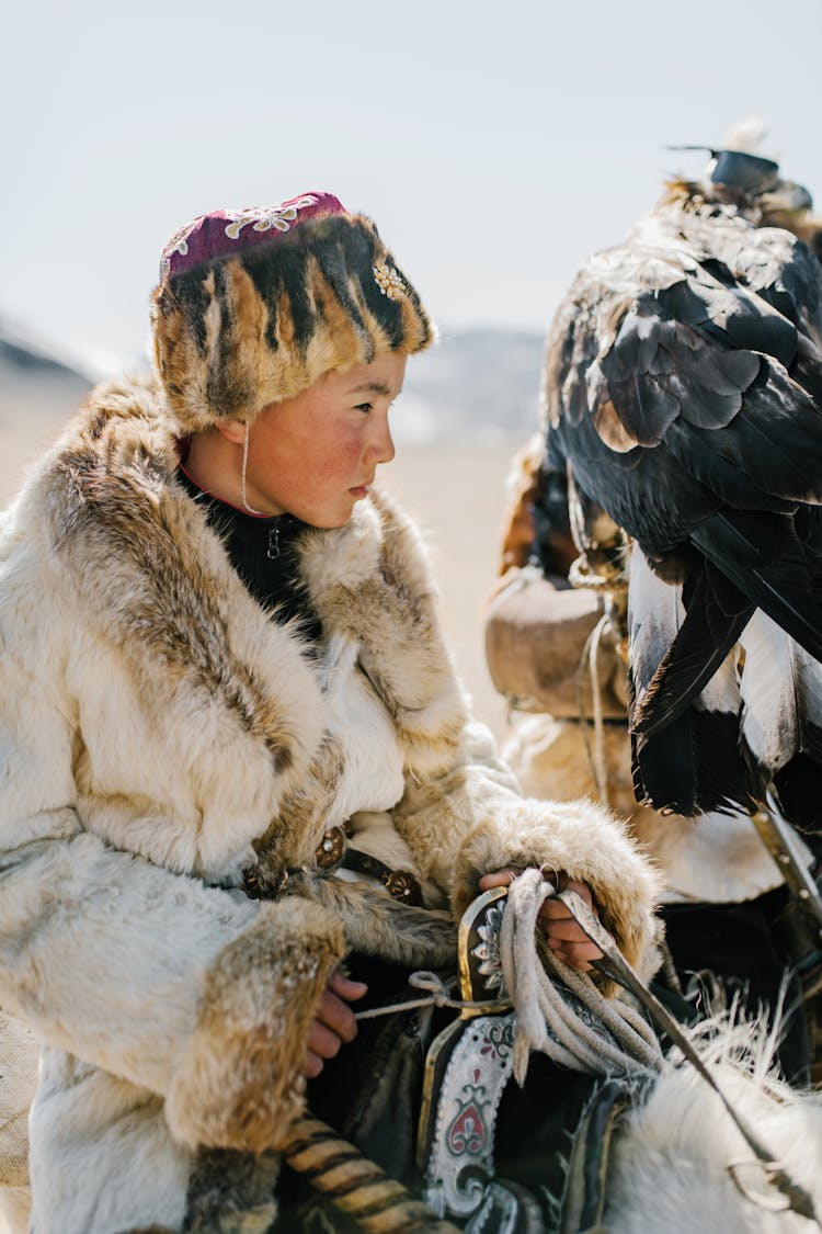 Focused Mongolian Teenager Boy Riding Horse During Eagle Hunting