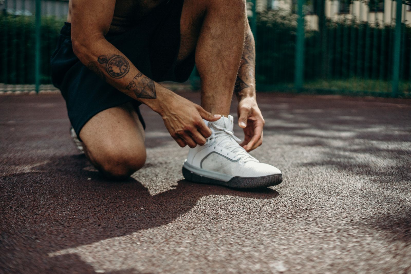 Runner tying closed toe compression socks before an outdoor training session