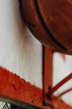 Close-up of a basketball making contact with a worn backboard, showcasing texture and detail.