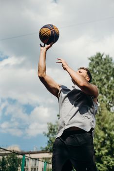 Action shot of a man playing basketball outdoors, capturing a dynamic moment.