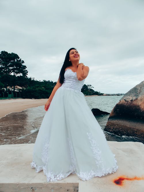 Bride in Wedding Dress Standing on Shore