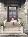 Anonymous trendy woman spinning around near entrance of medieval house