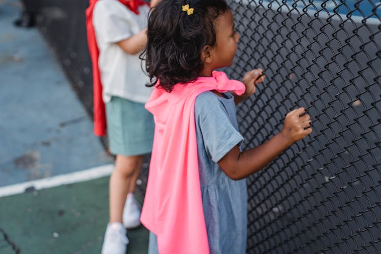 Children Looking Through Fence