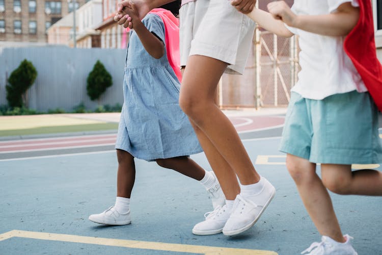 Girls In White Snickers Walking On A Playground