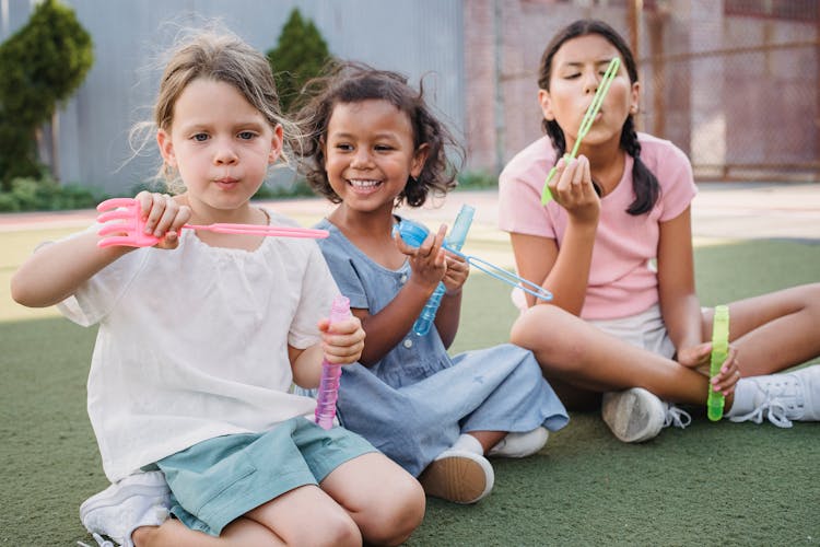 Happy Children Blowing Bubbles Outdoors