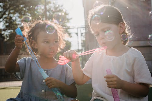 Children Blowing Bubbles Outdoors