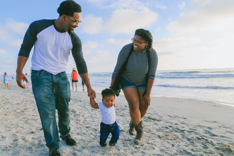 Black family walking together on the beach on vacation