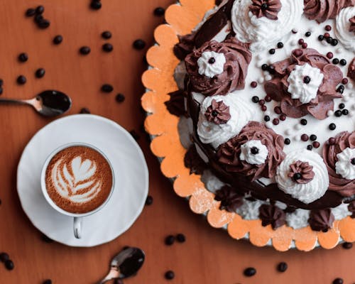 Chocolate Cake With White Icing beside a Coffee on a Ceramic Cup 