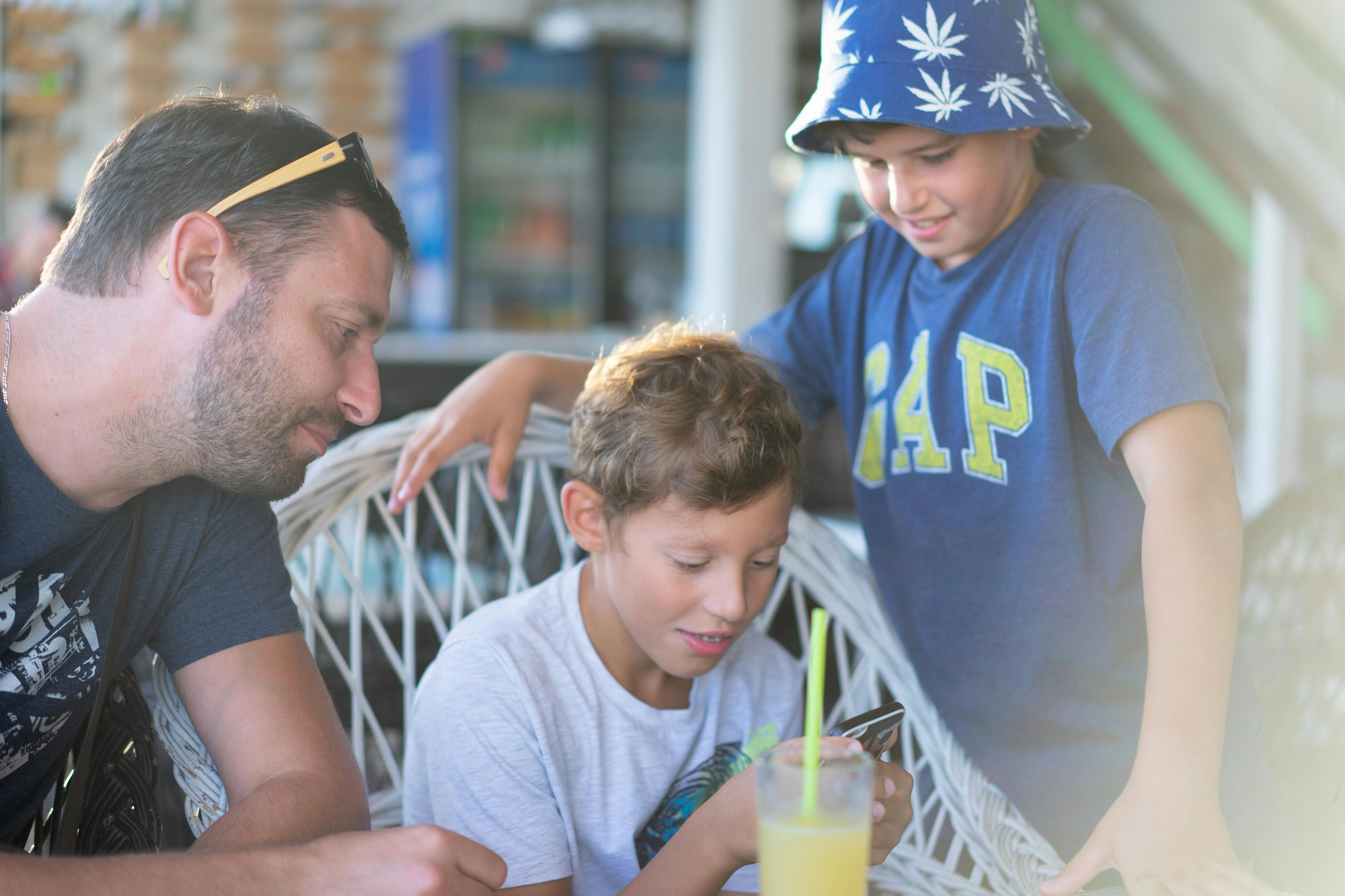 Family with older children looking at phone together