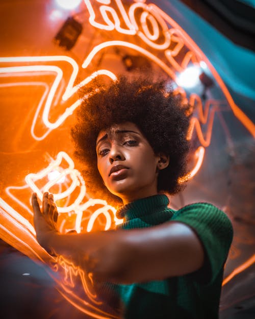 Portrait of Woman Standing Under Neon Sign