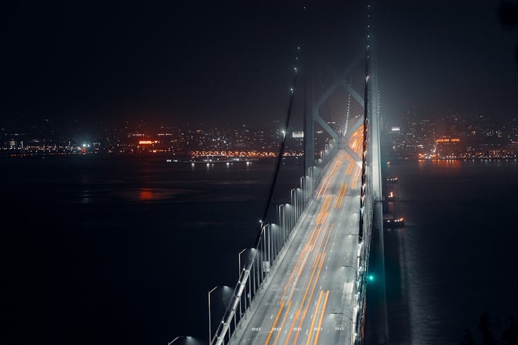 High Suspension Bridge Over River At Night