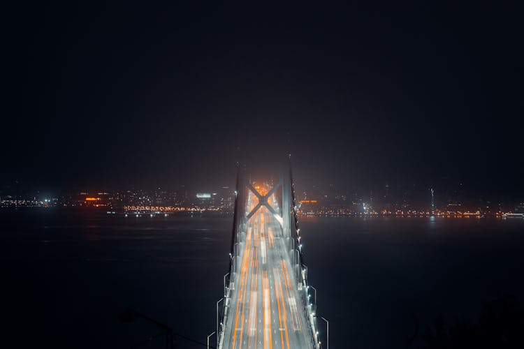 Suspension Bridge Over River At Night