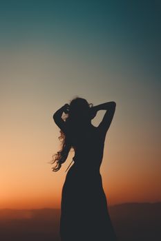 迷人的女性轮廓在黄金时段的日落背景下显得格外充满活力