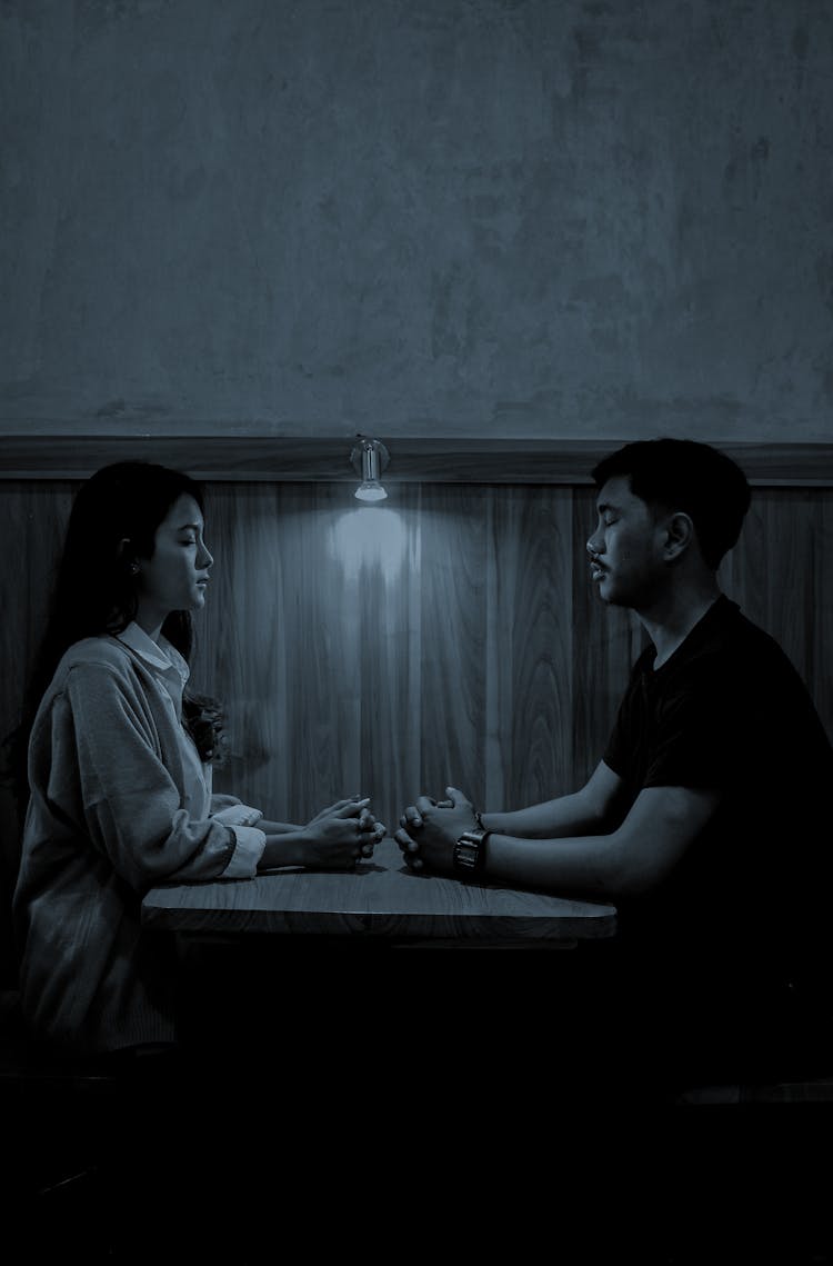 Asian Couple At Table In Cafe At Night