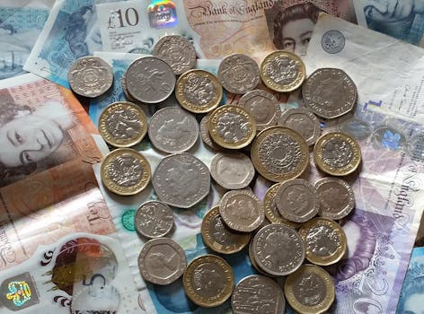 A detailed image of British Pound Sterling coins and banknotes, perfect for finance-related projects.