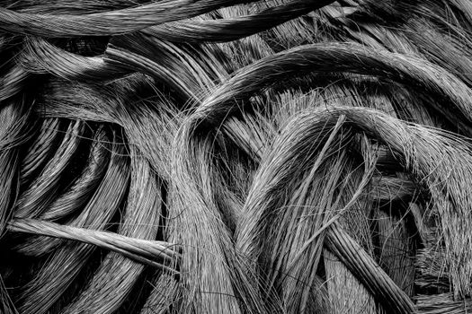 Intricate black-and-white close-up of intertwined metal wires showcasing industrial textures.