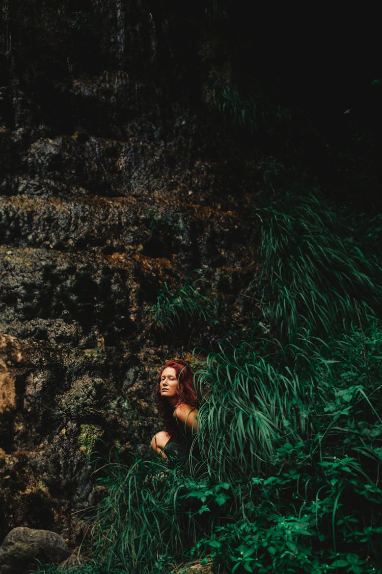 Woman Sitting In Lush Bush