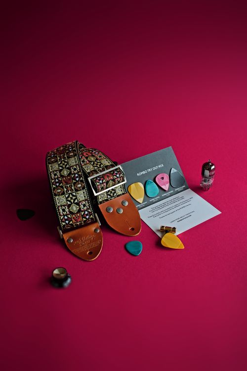 Free A vibrant display of guitar picks, strap, and accessories on a red background. Stock Photo