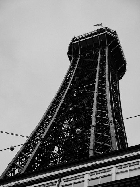 Dramatic black and white shot of Blackpool Tower captured from below, showcasing its iron structure.