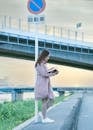 Woman Reading Book On Roadside