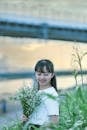 A Young Woman with a Beautiful Smile Holding a Bouquet of Flowers