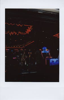 Vibrant neon lights illuminate a dark arcade interior, creating a retro gaming atmosphere.