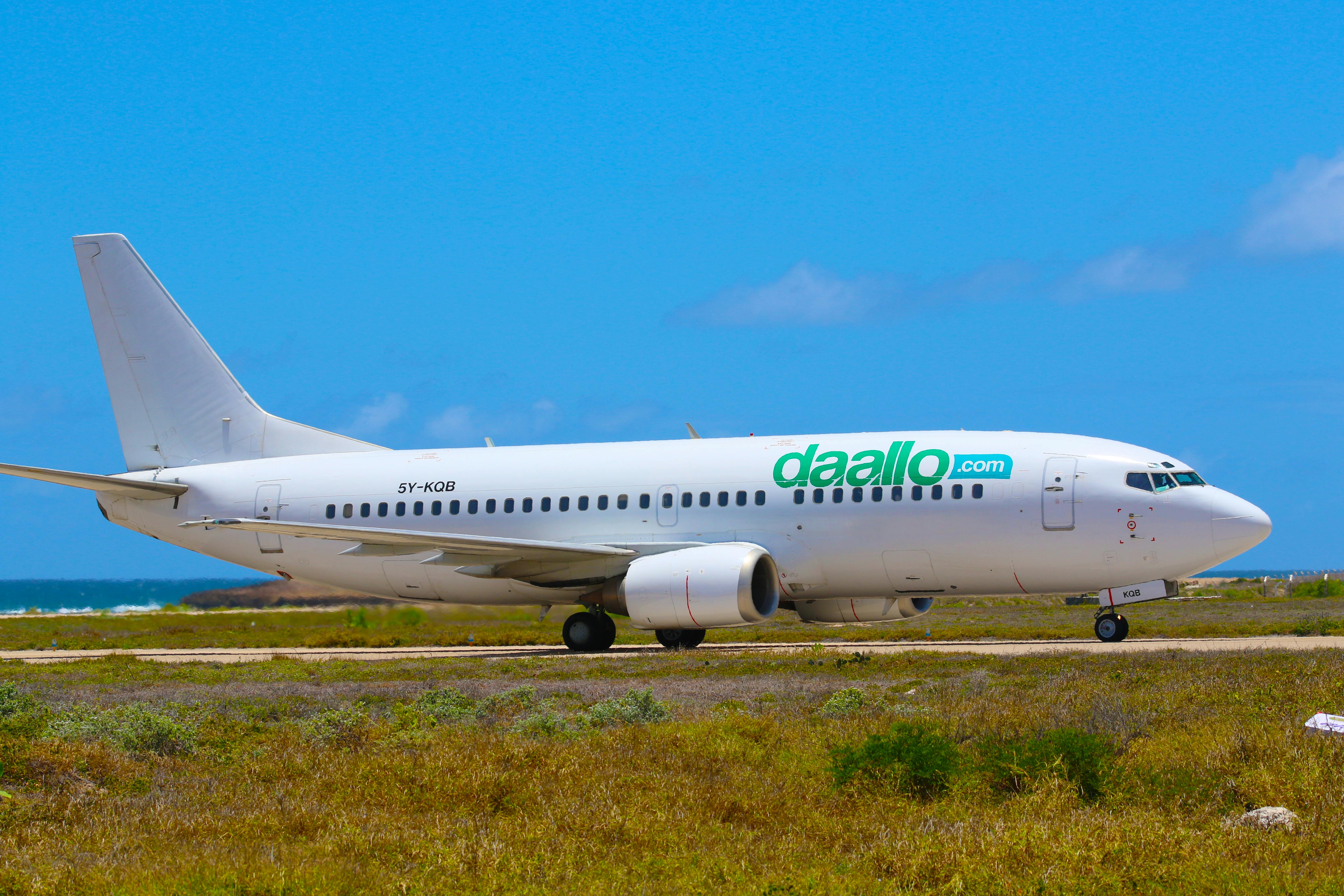 Airplane parked at Mogadishu airstrip, clear day view of Daallo Airlines jet.