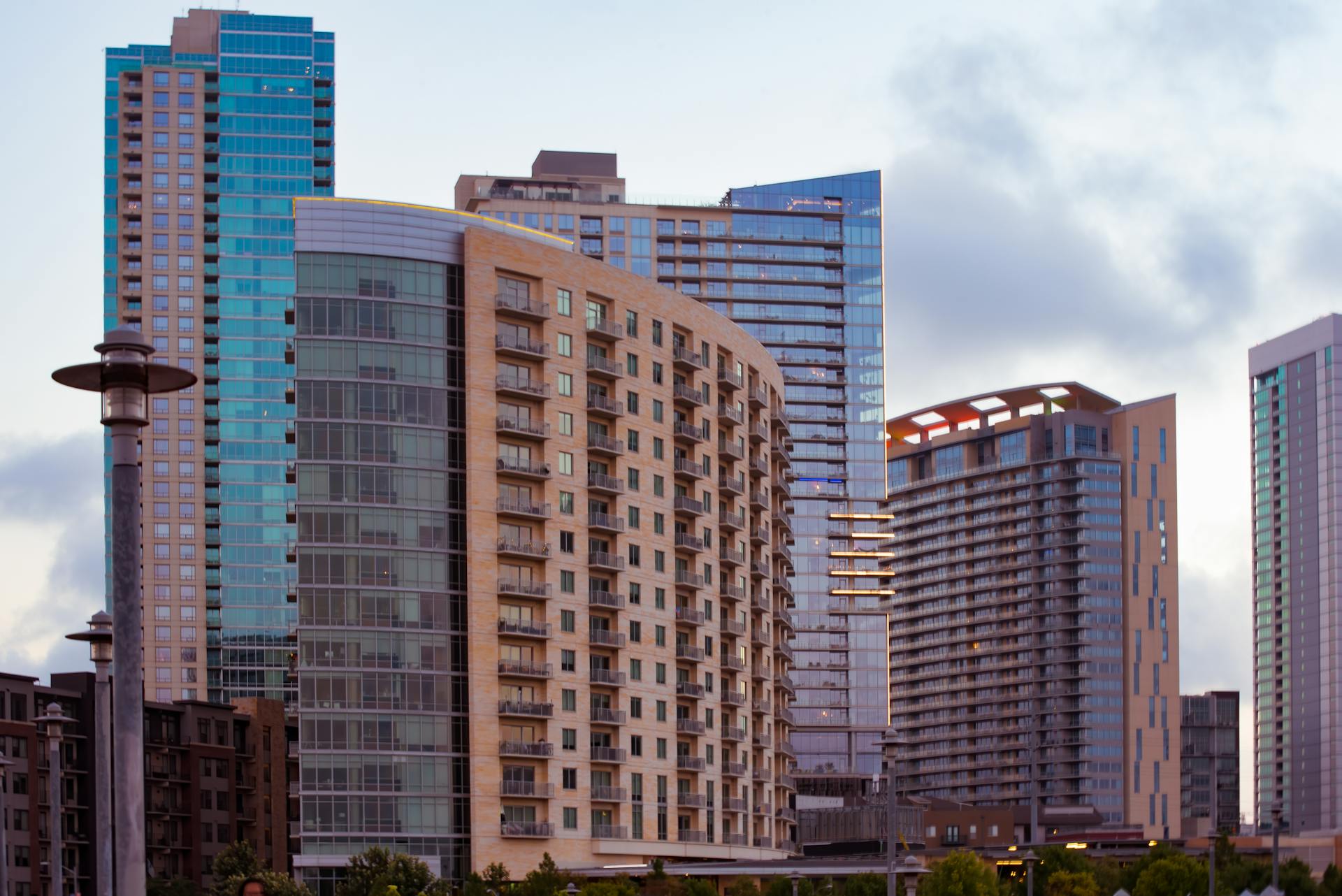 View of contemporary skyscrapers in downtown Austin, Texas with a cloudy sky backdrop.