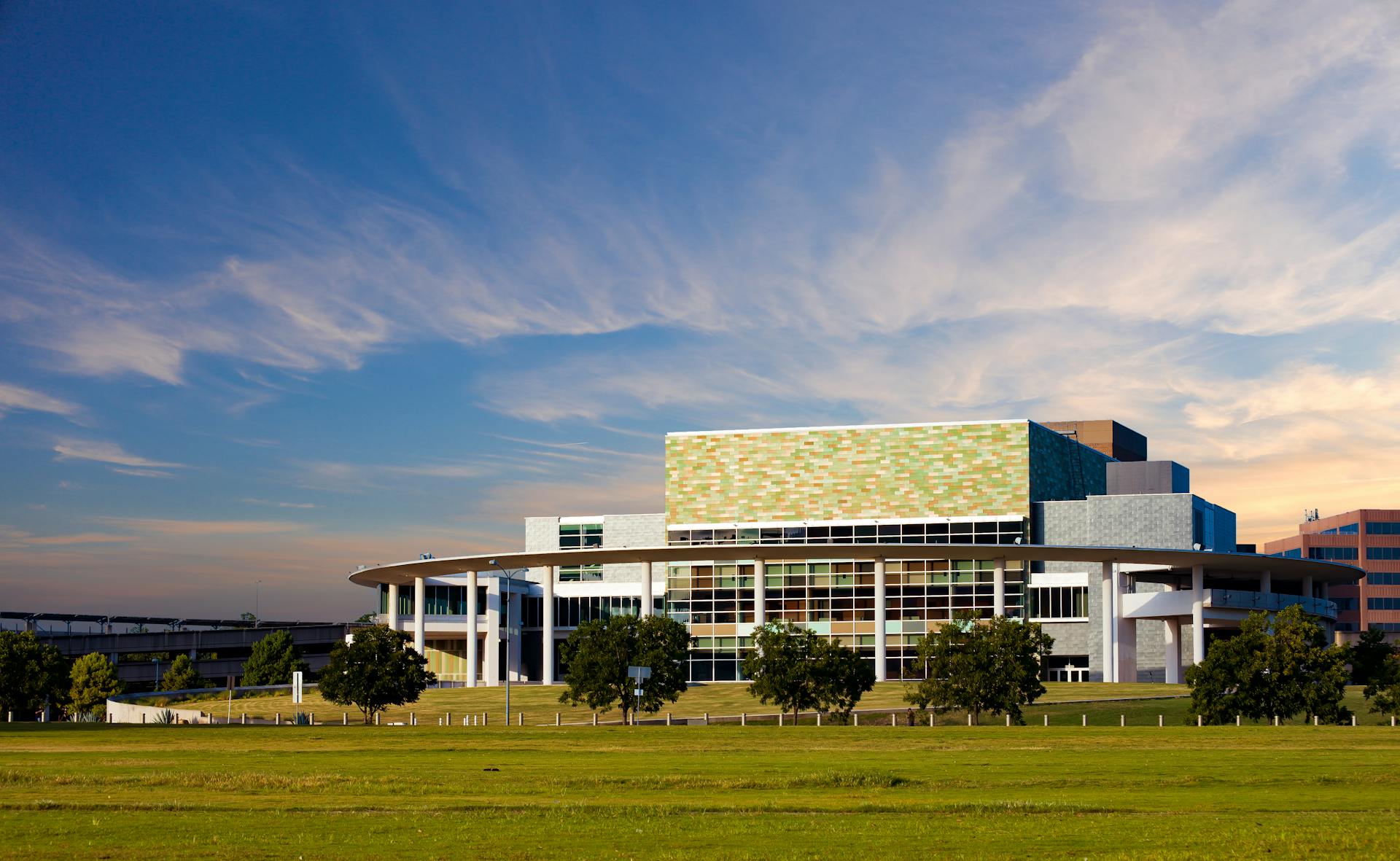 A modern architectural building in Austin, Texas captured under a clear sky with wide green space.