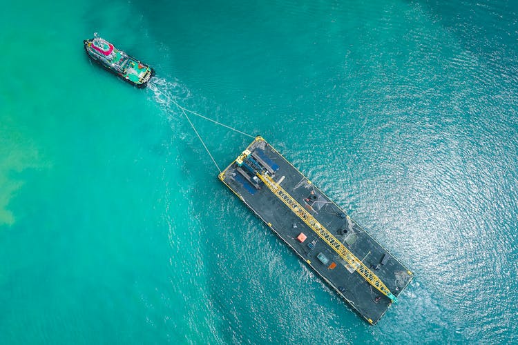 Aerial View Of Motorboat Transporting Platform On Seawater