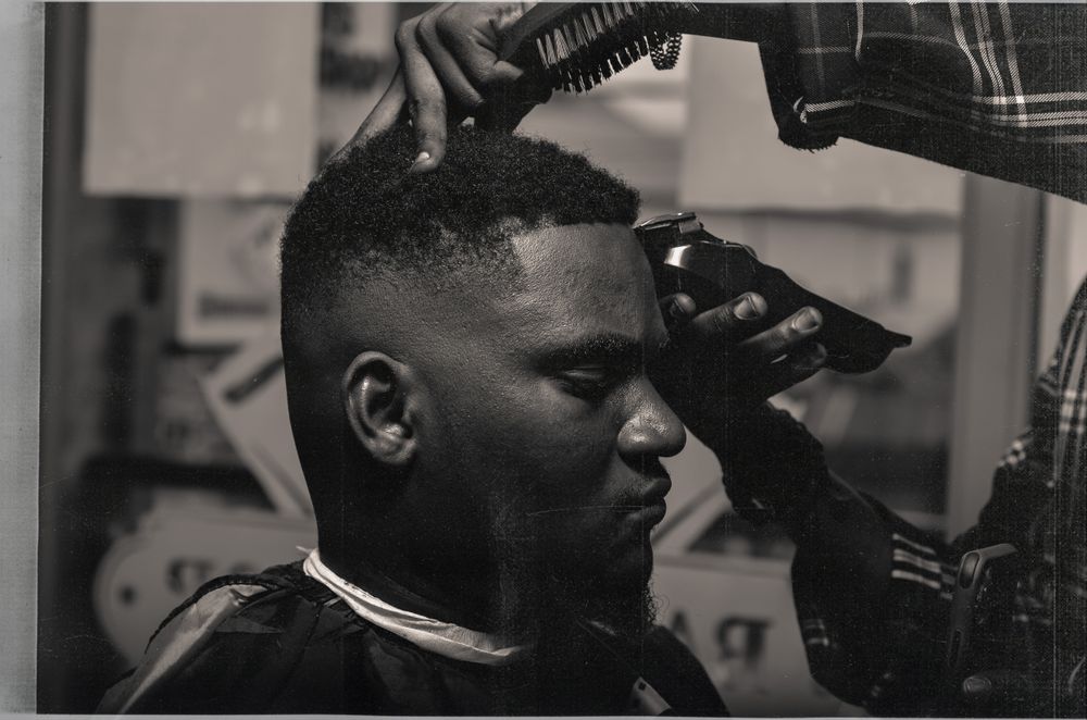 Barbero realizando un corte de precisión, imagen en blanco y negro