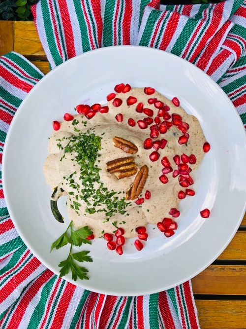 Free Vibrant Chile en Nogada dish with walnut sauce and pomegranate seeds, representing Mexican cuisine. Stock Photo
