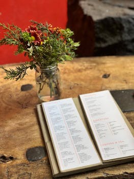 A charming menu card and floral arrangement on a rustic wooden table in a Mexican restaurant.