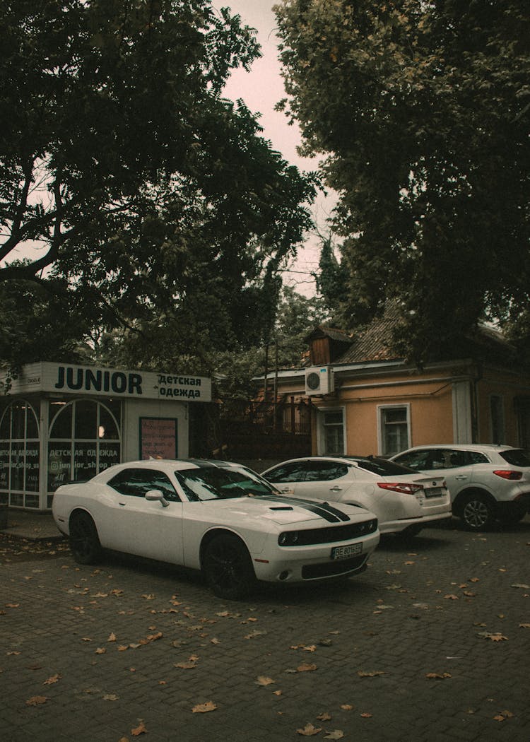 White Cars Parked Beside A Building