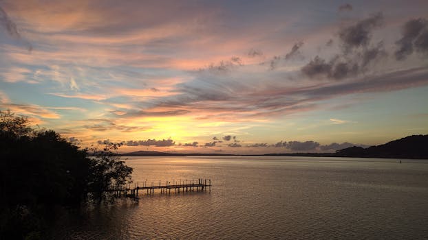 Breathtaking sunset view over a tranquil pier in Santa Catarina, Brazil, capturing the serene beauty of nature.