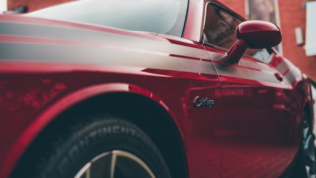 Detailed view of a polished red sports car showcasing its sleek design and modern finish.