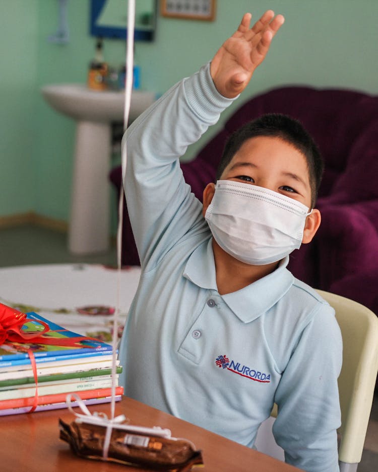 Diligent Student With Face Mask Raising His Hand