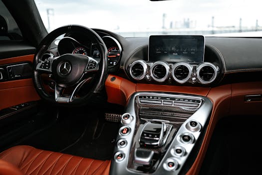 Close-up of a sleek luxury car interior featuring leather upholstery, advanced dashboard, and steering wheel.