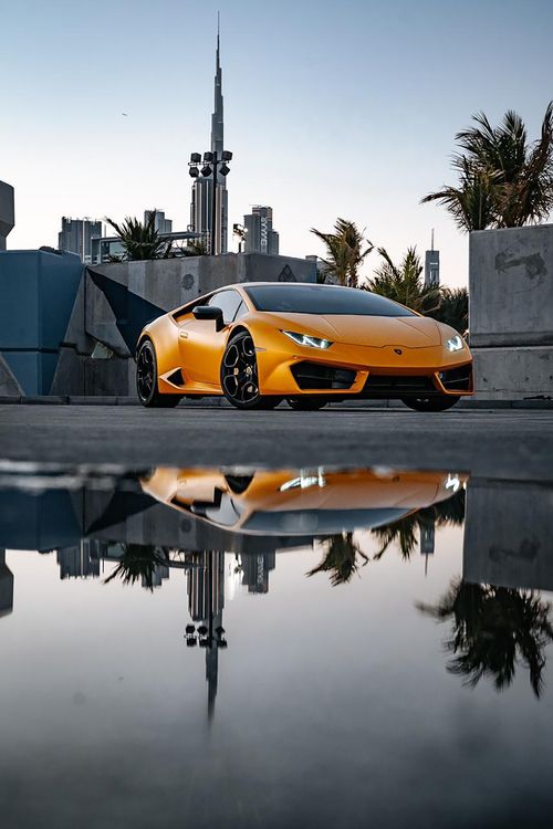 Free Striking image of a luxury Lamborghini with its reflection in an urban cityscape, showcasing elegance and speed. Stock Photo