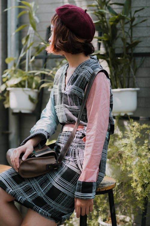 Free Unrecognizable Asian woman in stylish outfit on stool in garden Stock Photo