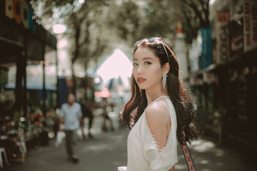 Chic young woman stands confidently on a city street, exuding elegance and modern style.