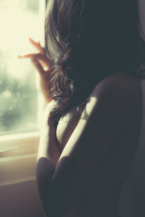 Nude woman near window in morning