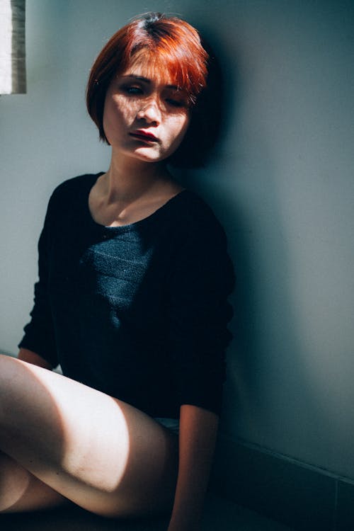 Free Unhappy female sitting on floor at sunlight Stock Photo