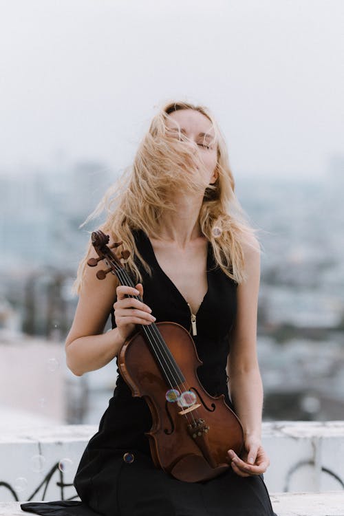 Woman with violin standing on roof