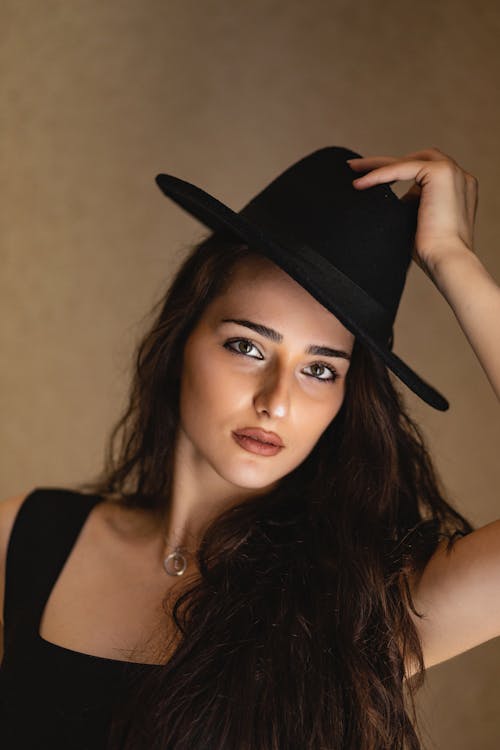 Woman in Black Tank Top Wearing Fedora Hat