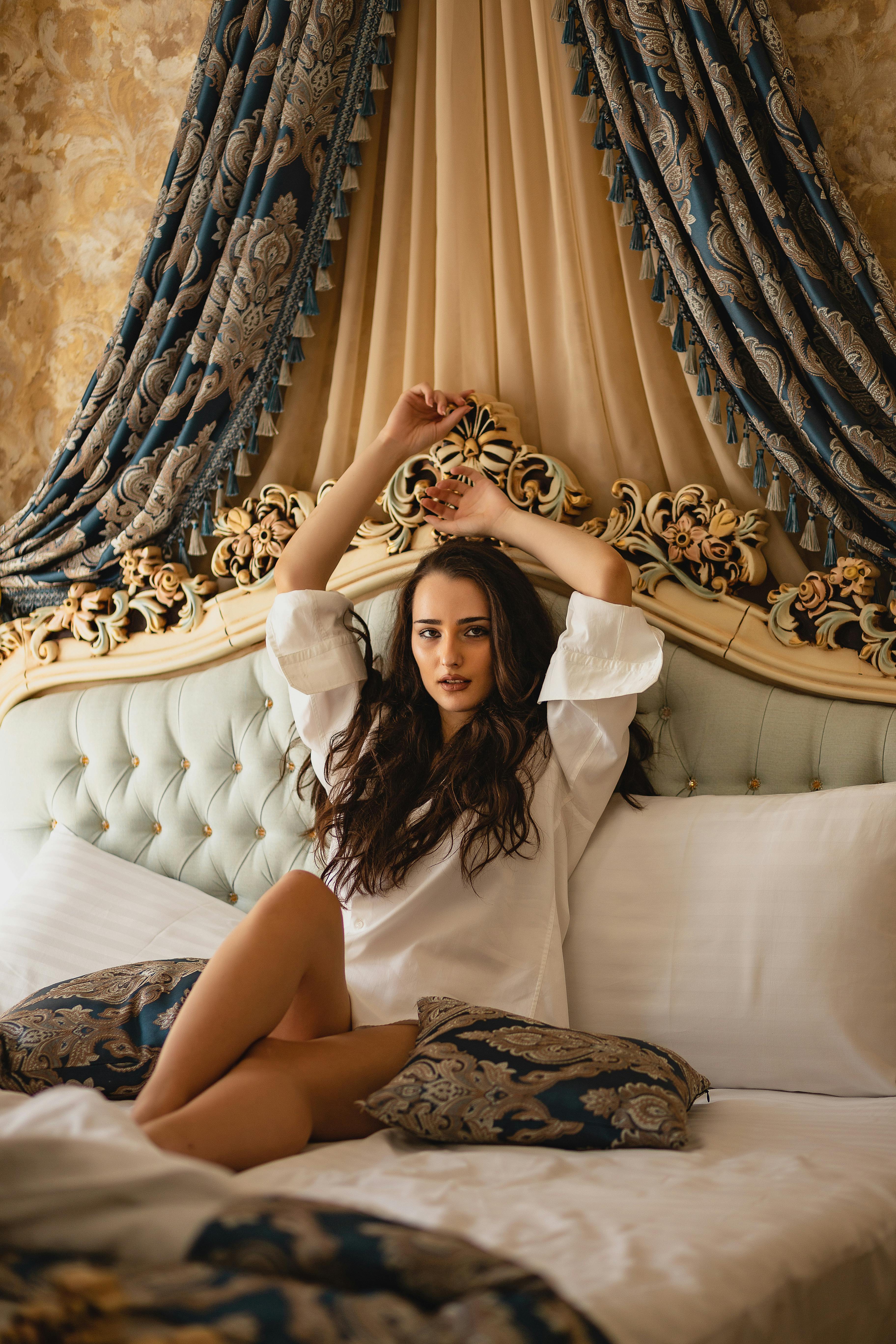 woman in white long sleeves sitting on the bed