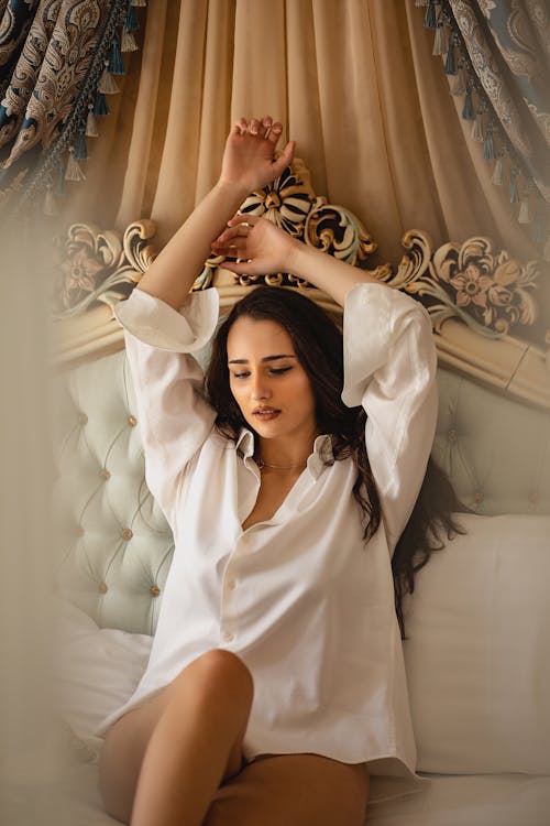 Free Woman in White Long Sleeve Shirt Reclining on the Bed Stock Photo