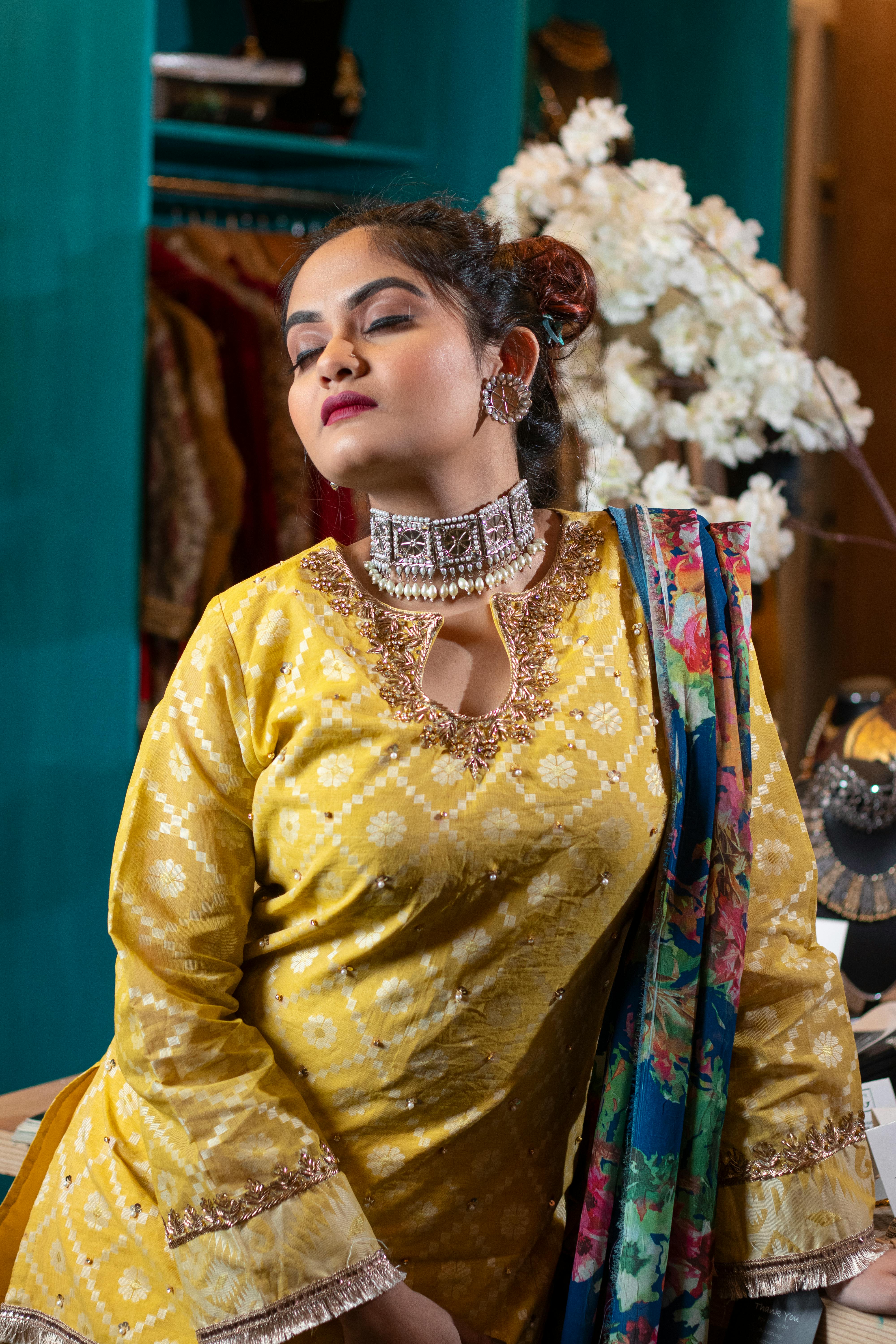 Elegantly dressed woman wearing statement earrings, necklace and a colourful scarf — the art of accessorising after 60