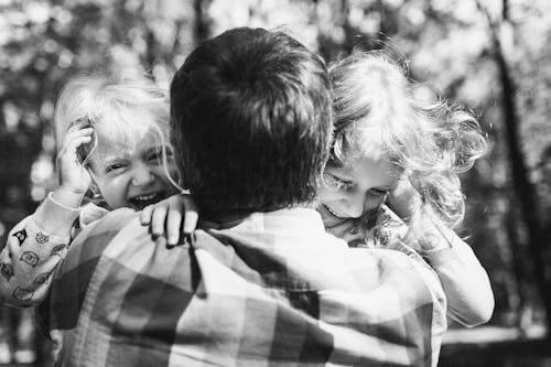 Free A Father Hugging His Daughters Stock Photo