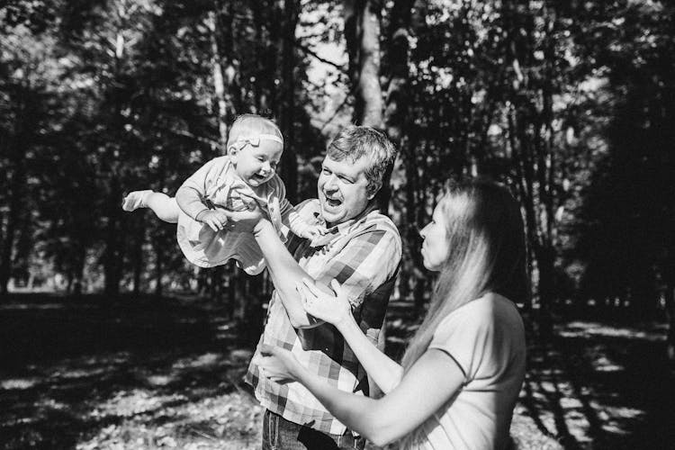 A Grayscale Of A Father Lifting Her Daughter